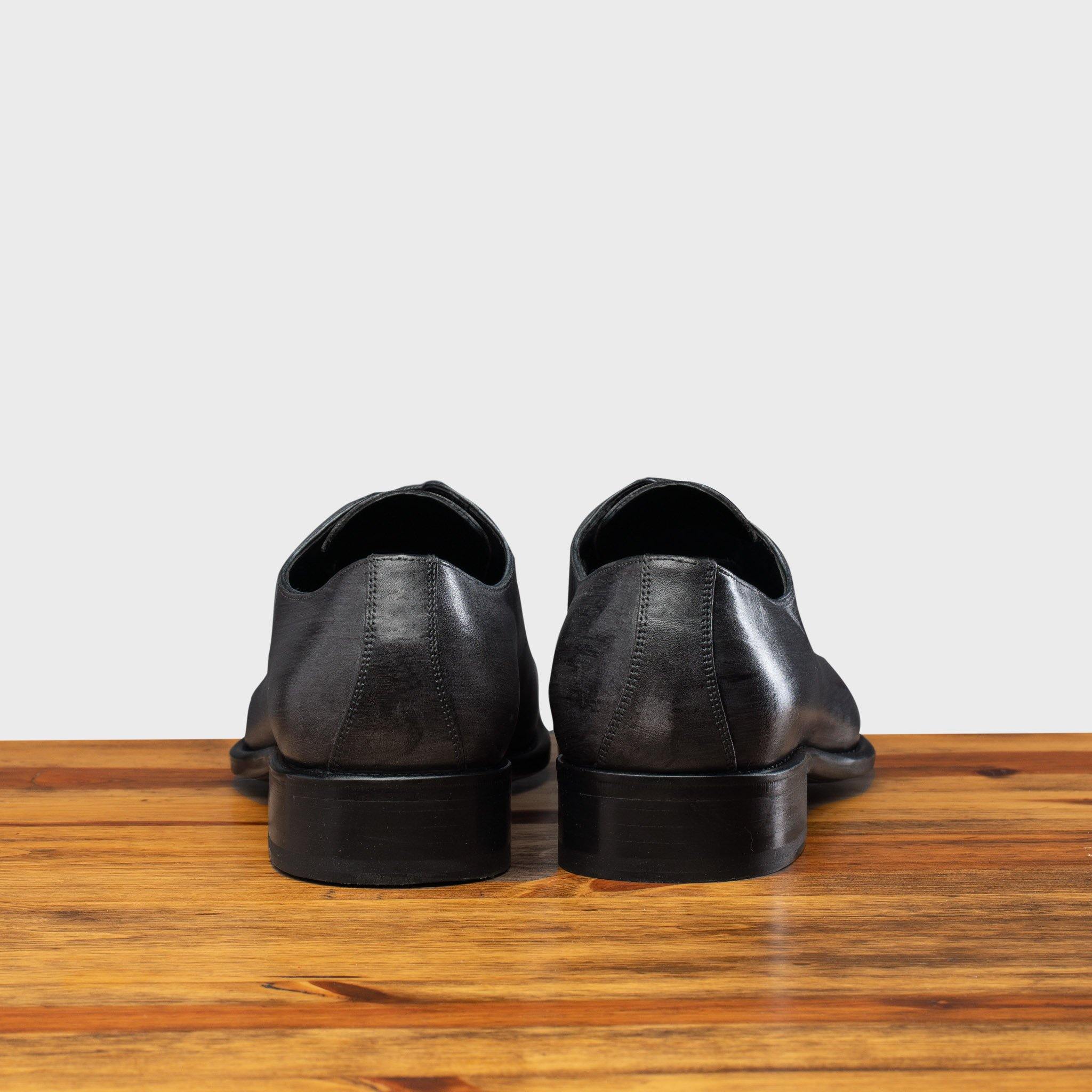 Back profile of 4633 Calzoleria Toscana Grey Cayenne Calf Wholecut Balmoral on top of a table